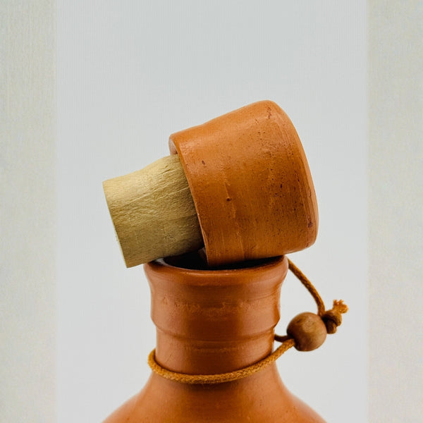 Close-up of clay bottle wooden cork lid with jute rope and wooden bead accent