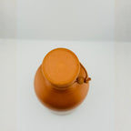 Top view of handmade clay water bottle opening with wooden cork lid and rope detail